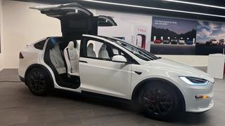 White Tesla car with the doors opened upward that symbolizes a self-driving car accident lawyer.