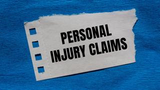 Torn paper with bold text reading 'Personal Injury Claims' on a textured blue background.